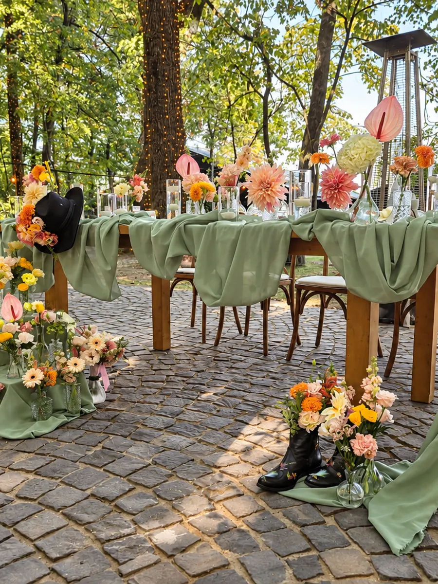 Masa prezidiului în aer liber, cu voal verde și flori colorate la bază